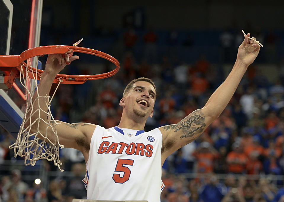 Florida guard Scottie Wilbekin (5) holds up a piece of the net after the Gators became the first team in Southeastern Conference history to go 18-0 in league pla, Saturday, March 8, 2014 in Gainesville, Fla. Florida defeated Kentucky 84-65 Saturday in an NCAA college basketball game. (AP Photo/Phil Sandlin)