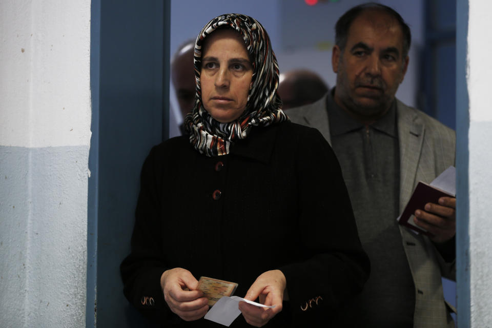A woman and a man wait for voting at a polling station during the local elections, in Istanbul, Sunday, March 31, 2019. Turkish citizens have begun casting votes in municipal elections for mayors, local assembly representatives and neighbourhood or village administrators that are seen as a barometer of Erdogan's popularity amid a sharp economic downturn.(AP Photo/Lefteris Pitarakis)