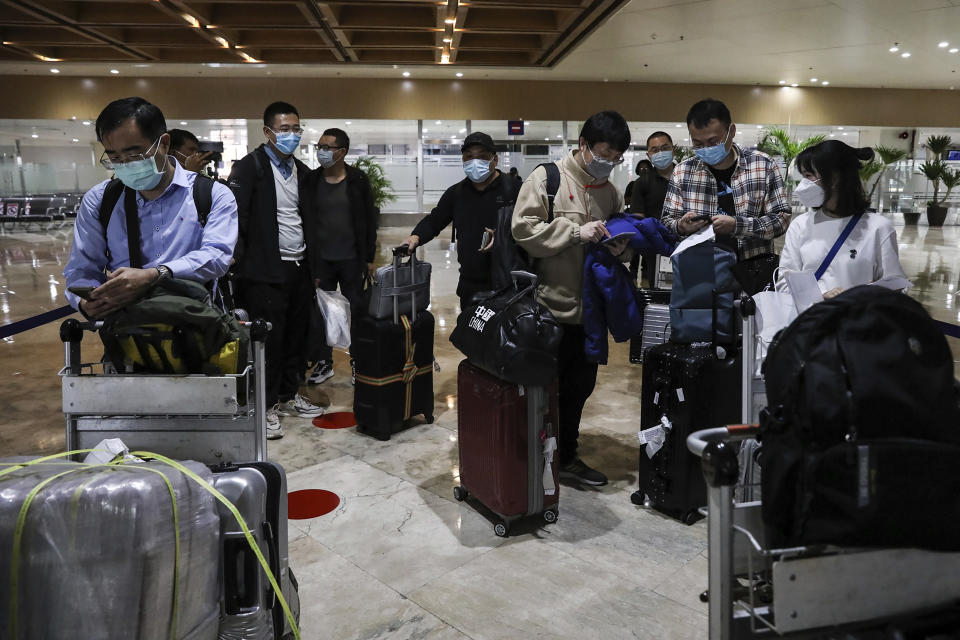Foreign passengers wearing protective masks as precaution against the spread of the coronavirus arrive at Manila's International Airport, Philippines Thursday, Feb. 10, 2022. The Philippines lifted a nearly 2-year ban on foreign travelers Thursday in a lifesaving boost for its tourism and related industries as an omicron-fueled surge eases. (AP Photo/Basilio Sepe)