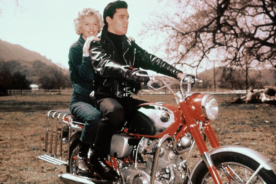 American actors Barbara Stanwyck and Elvis Presley on the set of Roustabout, directed by John Rich. (Photo by Sunset Boulevard/Corbis via Getty Images)