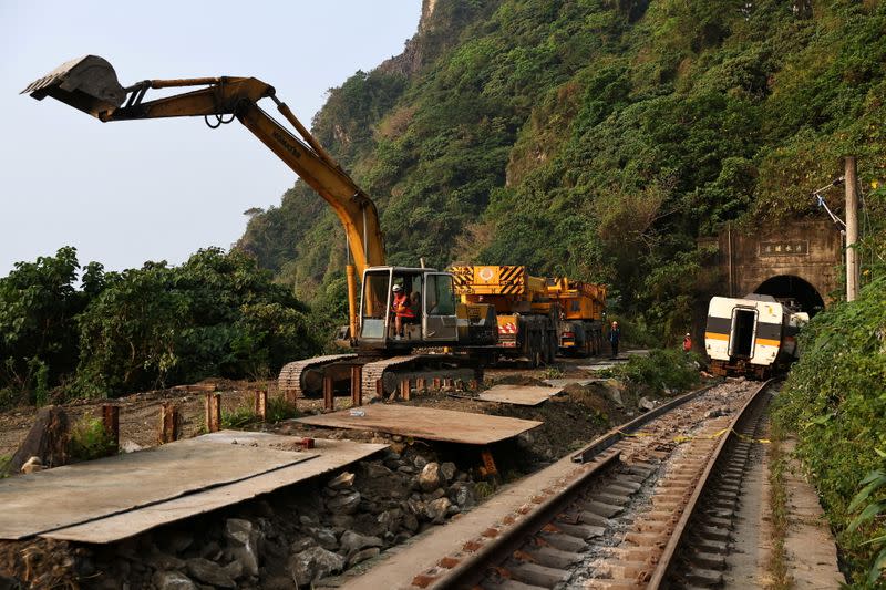 Rescuers work at the site a day after a deadly train derailment at a tunnel north of Hualien