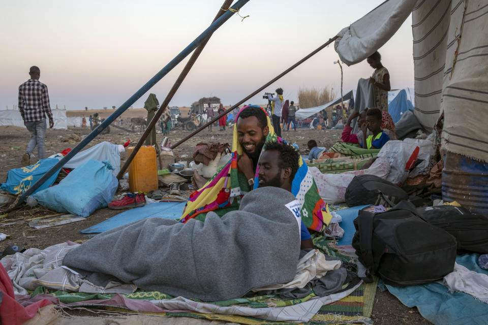 Tigray refugees who fled the conflict in the Ethiopia's Tigray sit up after waking up early morning at Hamdeyat Transition Center near the Sudan-Ethiopia border, eastern Sudan, Thursday, Dec. 3, 2020. Ethiopian forces on Thursday blocked people from the country's embattled Tigray region from crossing into Sudan at the busiest crossing point for refugees, Sudanese forces said.(AP Photo/Nariman El-Mofty)