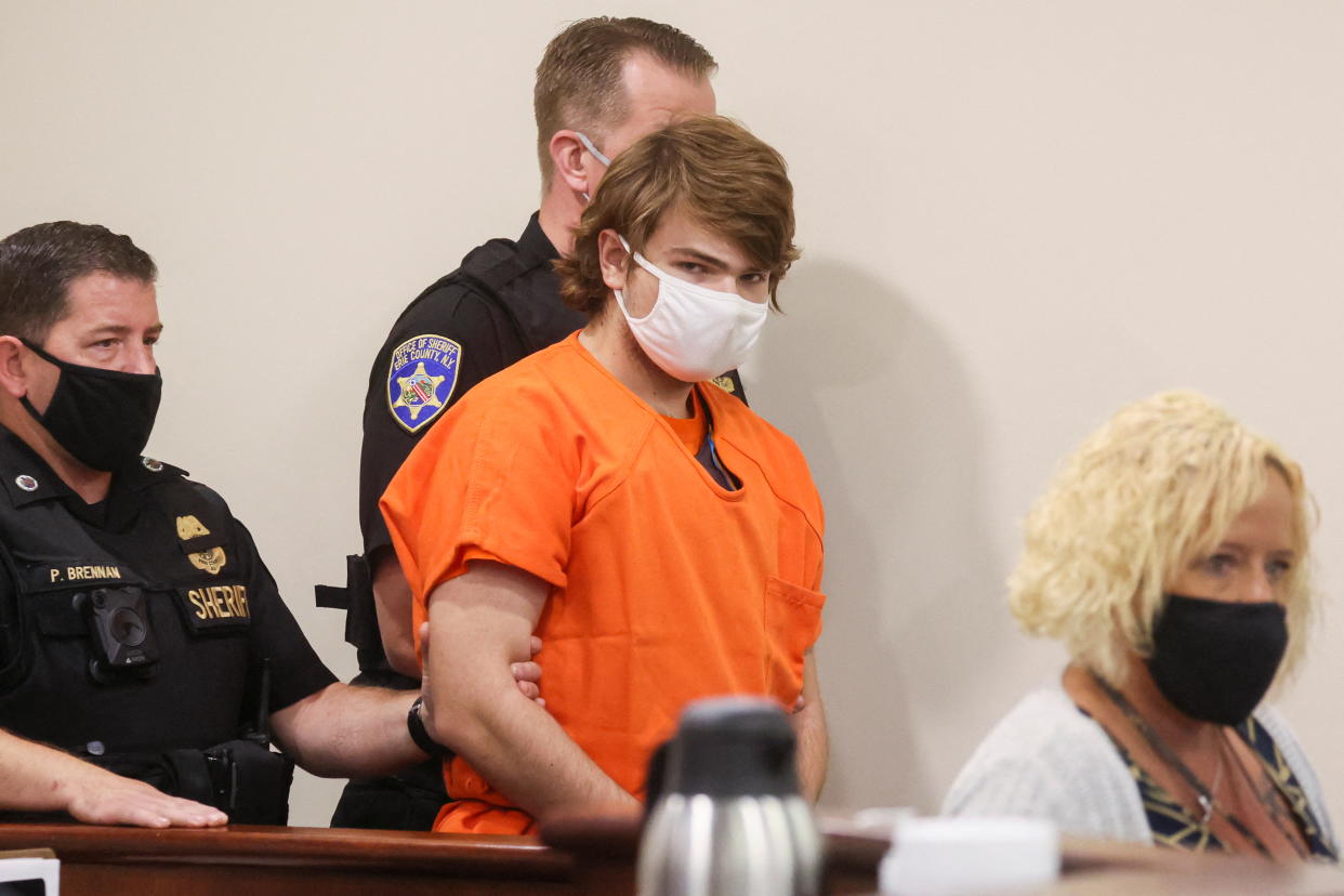 Payton Gendron, wearing a mask and orange prison clothing, appears in court.