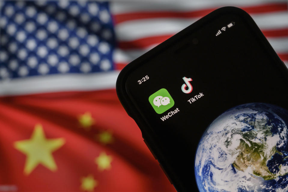 BEIJING, CHINA - SEPTEMBER 22: In this photo illustration, a mobile phone can be seen displaying the logos for Chinese apps WeChat and TikTok in front of a monitor showing the flags of the United States and China on an internet page, on September 22, 2020 in Beijing, China. Both popular Chinese-owned apps are facing bans under an executive order signed by United States President Donald Trump, but on Saturday, Trump said he was giving the go ahead to a deal between TikTok, Oracle, and Walmart and a judge in California issued a preliminary injunction blocking the administrations WeChat ban. (Photo by Kevin Frayer/Getty Images)
