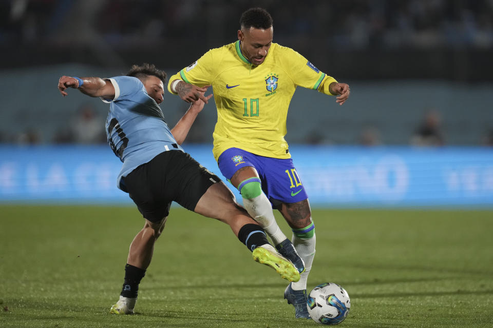 Brazil's Neymar, right, and Uruguay's Manuel Ugarte battle for the ball during a qualifying soccer match for the FIFA World Cup 2026 at Centenario stadium in Montevideo, Uruguay, Tuesday, Oct. 17, 2023. (AP Photo/Matilde Campodonico)