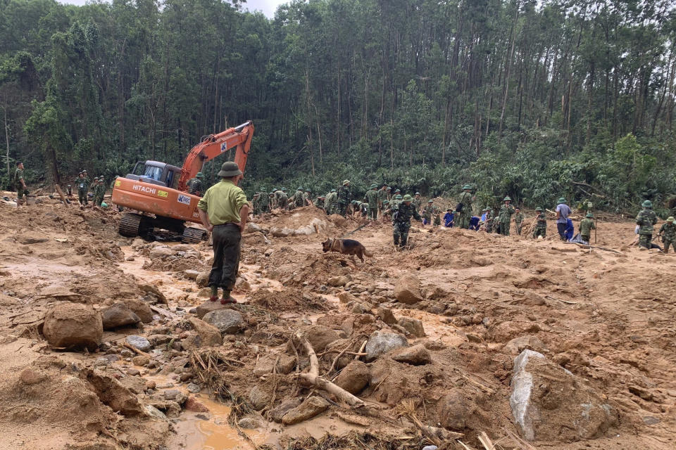 Rescue workers recover bodies of army officers buried in a landslide in Thua Thien-Hue province, Vietnam, Thursday, Oct. 15, 2020. Rescuers recovered the bodies of 11 army personnel and two other people who were buried in the landslide while trying to reach victims of another landslide, state media reported Friday, Oct. 16, 2020. (Tran Le Lam/VNA via AP)