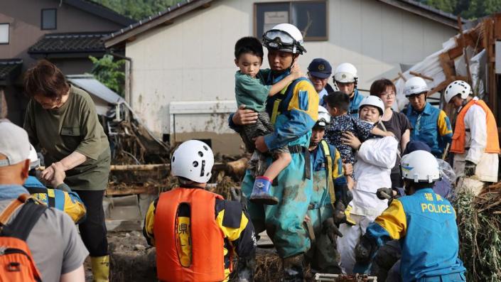 Los residentes son rescatados luego de una inundación en su calle en Tanushimarumachi en la ciudad de Kurume, prefectura de Fukuoka, el 10 de julio de 2023. - JIJI Press/AFP/Getty Images