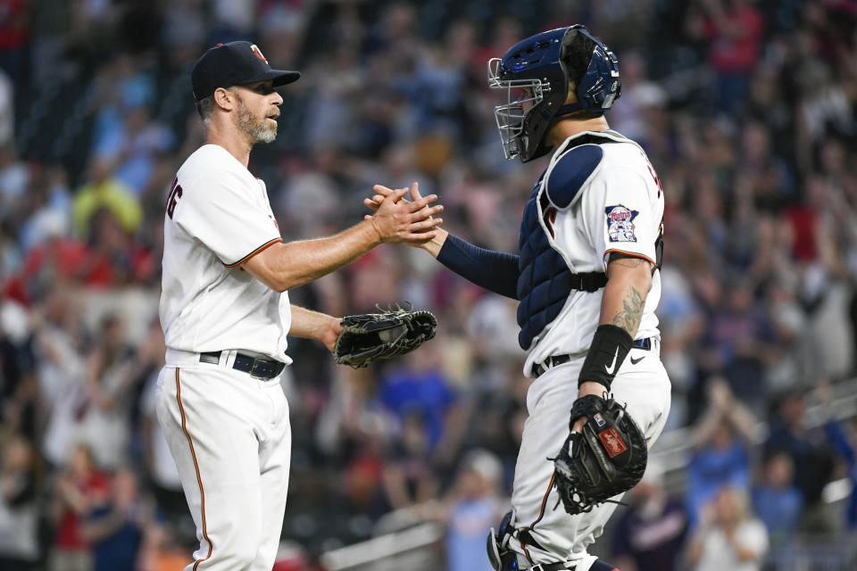 Minnesota Twins pitcher Tyler Thornburg, left, and catcher Gary Sanchez celebrate after defeating the Colorado Rockies in a baseball game, Saturday, June 25, 2022, in Minneapolis. (AP Photo/Craig Lassig)