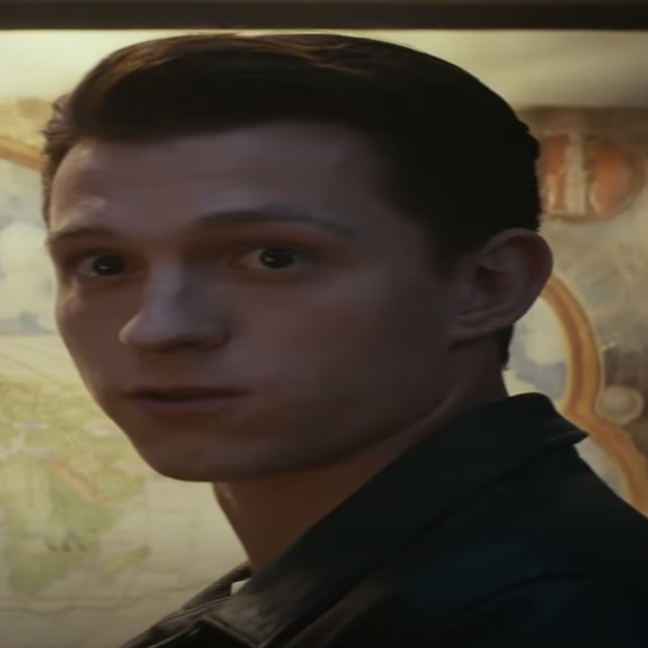 Tom as Drake standing in front of a map