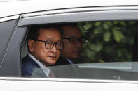 Cambodia's exiled opposition leader Sam Rainsy looks out from a car as he arrive at Parliament House in Kuala Lumpur, Tuesday, Nov. 12, 2019. Sam Rainsy landed in Kuala Lumpur in a bid to return to his homeland after Thailand had earlier blocked him from entering. (AP Photo/Vincent Thian)