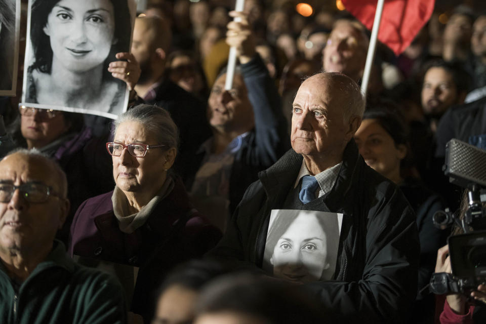 Rose and Michael Vella hold photos of their daughter, assassinated investigative journalist Daphne Caruana Galizia, as they partecipate in a demonstration in Valletta, Malta, Friday night, Nov. 29, 2019. The family of the journalist who was killed by a car bomb in Malta is urging Maltese Prime Minister Joseph Muscat to resign, after his former chief aide was released from jail in a probe aimed at finding the mastermind of the 2017 murder. (AP Photo/Rene' Rossignaud)