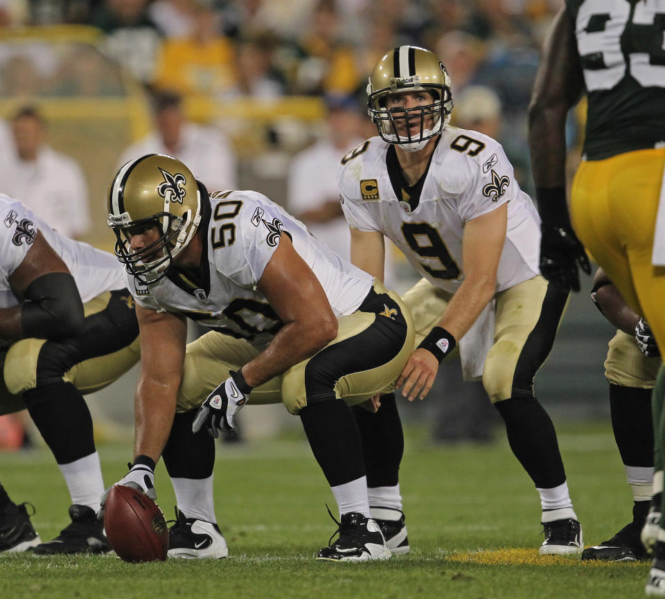 GREEN BAY, WI - SEPTEMBER 08: Olin Kreutz #50 of the New Orleans Saints prepares to snap the ball to Drew Brees #9 against the Green Bay Packers during the NFL opening season game at Lambeau Field on September 8, 2011 in Green Bay, Wisconsin. (Photo by Jonathan Daniel/Getty Images)