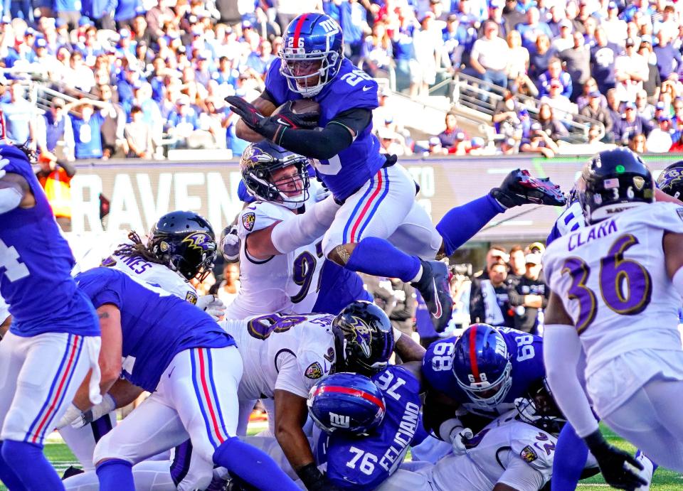 New York Giants running back Saquon Barkley (26) scores the game-winning touchdown during the fourth quarter to beat the Baltimore Ravens at MetLife Stadium.