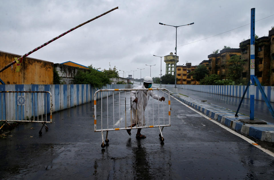 A police officer moves a barricade to block a road leading to a flyover before Cyclone Amphan makes its landfall, in Kolkata, India, May 20, 2020. REUTERS/Rupak De Chowdhuri