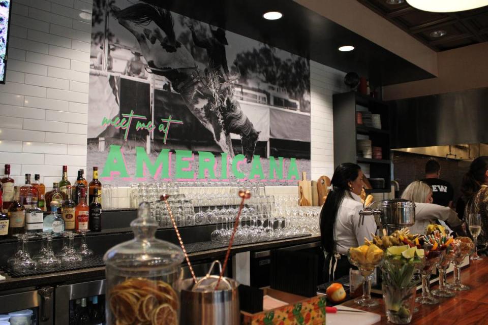 Subway tiles connect the bar and the kitchen at Cafe Americana. “Meet me at Cafe Americana” reads the sign that features a Texas cowboy with the bright and vibrant colors.