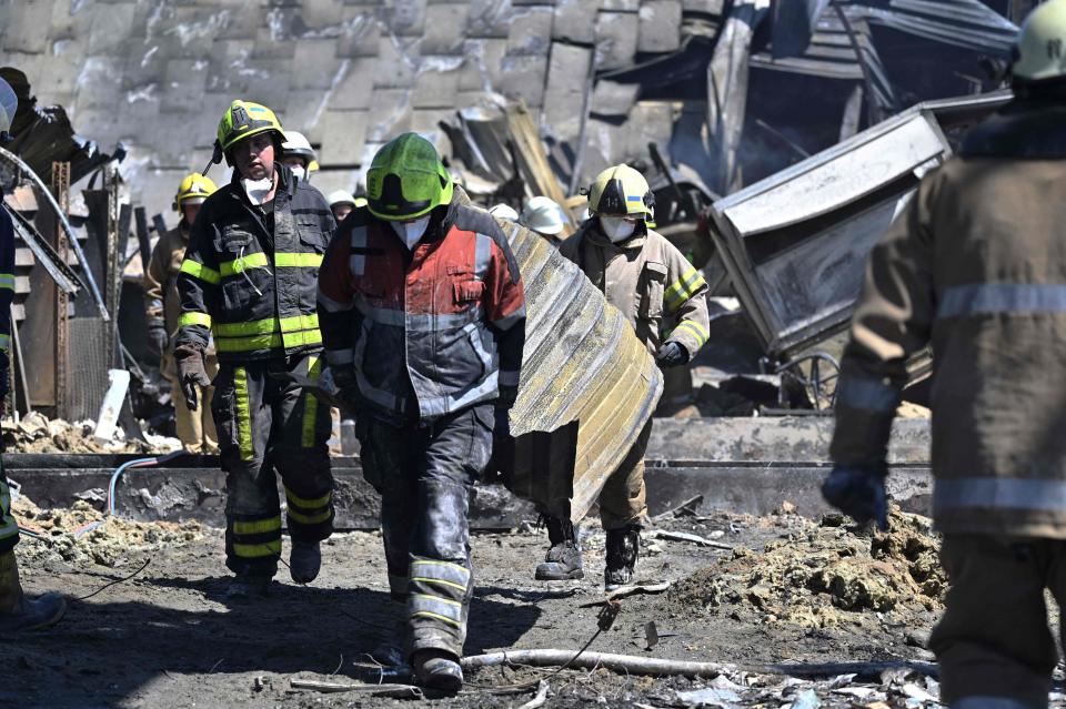 Workers are seen clearing the rubbles of the Amstor mall, after it was hit by a Russian missile strike according to Ukrainian authorities in Kremenchuk (Getty Images)