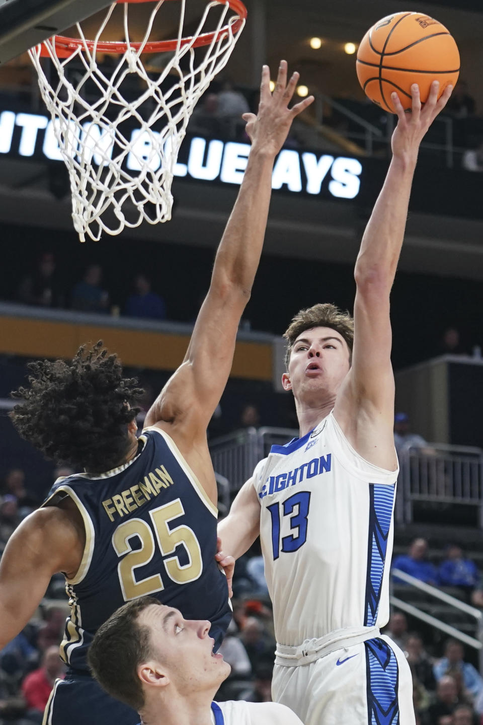 Creighton's Mason Miller (13) shoots over Akron's Enrique Freeman (25) during the second half of a first-round college basketball game in the NCAA Tournament, Thursday, March 21, 2024, in Pittsburgh. (AP Photo/Matt Freed)