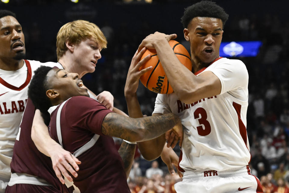 Alabama guard Rylan Griffen (3) rebounds with Texas A&M guard Hayden Hefner, above left, and guard Wade Taylor IV (4), below left, defending during the first half of an NCAA college basketball game in the finals of the Southeastern Conference Tournament, Sunday, March 12, 2023, in Nashville, Tenn. (AP Photo/John Amis)