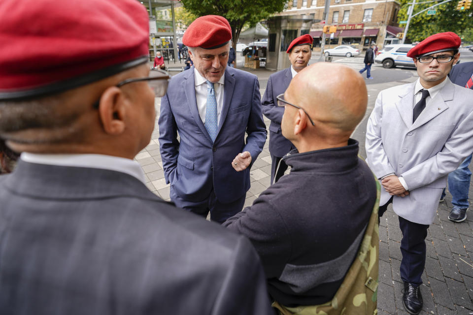 New York City Republican mayoral candidate Curtis Sliwa, center top, is surrounded by members of the Guardian Angels, a group he founded, as he speaks to a voter during a campaign event in the Washington Heights neighborhood of New York, Tuesday, Oct. 12, 2021. (AP Photo/Mary Altaffer)