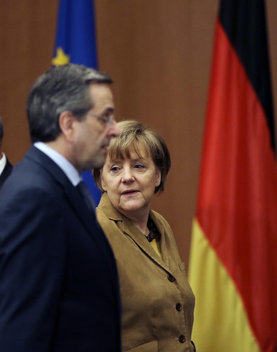 Greece's Prime Minister Antonis Samaras, left, and German Chancellor Angela Merkel arrive for a meeting with young Greek businessmen in Athens on Friday, April 11, 2014. Merkel arrived for a brief visit, a day after the crisis-hit country returned to international bond markets. Greece this week reached a milestone in the recovery from its financial crisis — it successfully tapped bond markets for the first time since 2010, raising 3 billion euros ($4.14 billion) in five-year debt. (AP Photo/Thanassis Stavrakis)