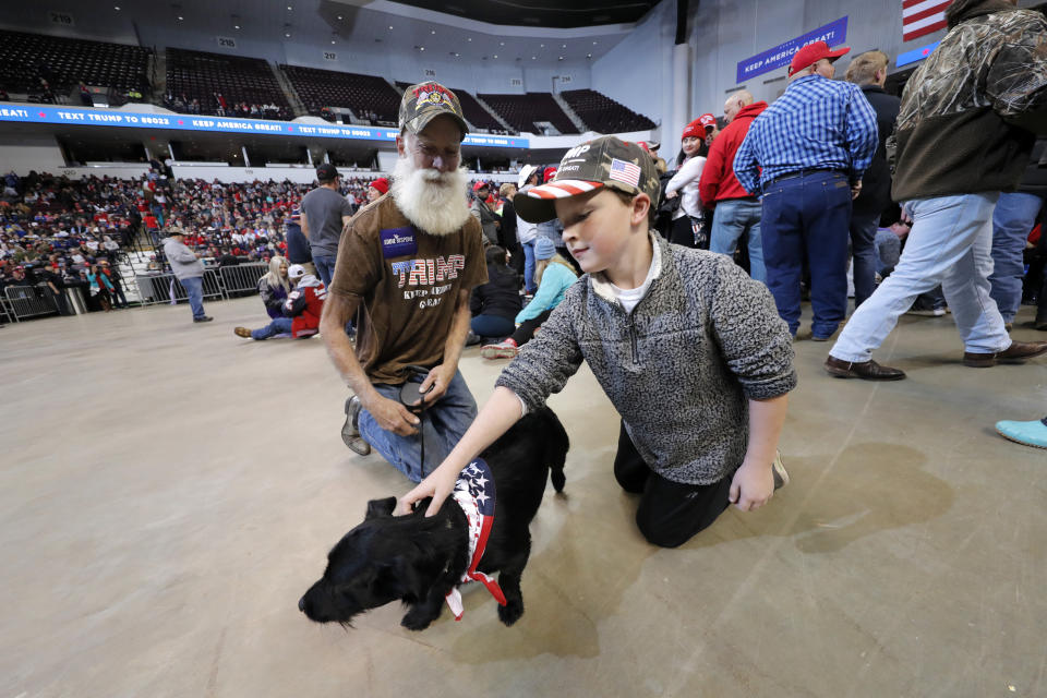 Dennis Kees, left, of Shreveport, La., attends a campaign rally for President Donald Trump with his dog "Big Joe" in Bossier City, La., Thursday, Nov. 14, 2019. (AP Photo/Gerald Herbert)