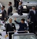 South Korean President Park Geun-hye (bottom R), accompanied by Defense Minister Kim Kwan-jin (bottom L), waves to the crowd during celebrations at the 65th anniversary of Korea Armed Forces Day, at a military airport in Seongnam, south of Seoul, October 1, 2013. (REUTERS/Kim Hong-Ji)