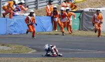 Mahindra Moto3 rider Miguel Oliveira of Portugal falls off his motorcycle as course marshals run toward him during the Japanese Grand Prix at the Twin Ring Motegi circuit in Motegi, north of Tokyo in this October 12, 2014 file photo. REUTERS/Toru Hanai/Files (JAPAN - Tags: SPORT MOTORSPORT TPX IMAGES OF THE DAY)