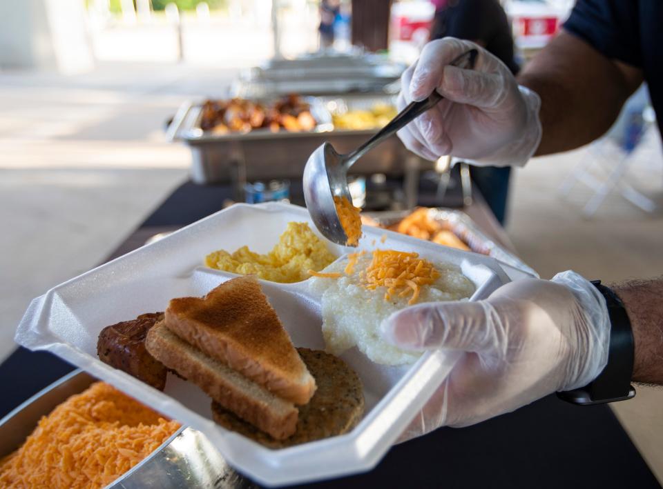 Carla King Richardson waits for cheese to be added to her grits during the sunrise brunch offered during the final day of the Inaugural Soul of  Southside Festival on Saturday, May 22, 2021.