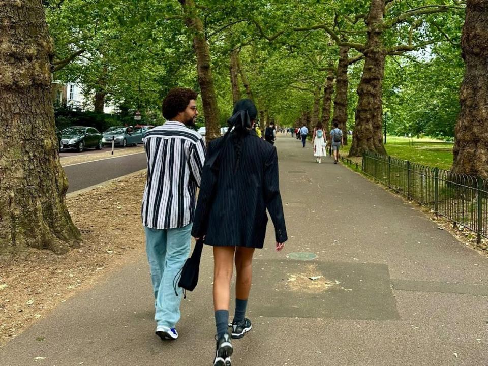 malik and a friend walking through hyde park in london on a clear day