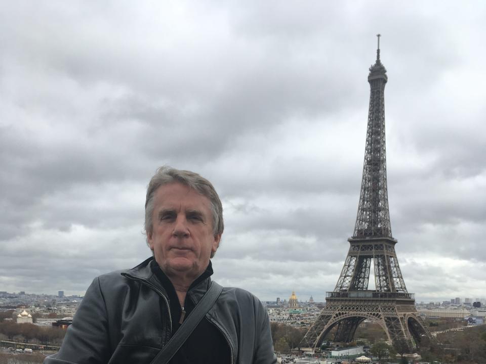 A man standing with the Eiffel Tower in the background