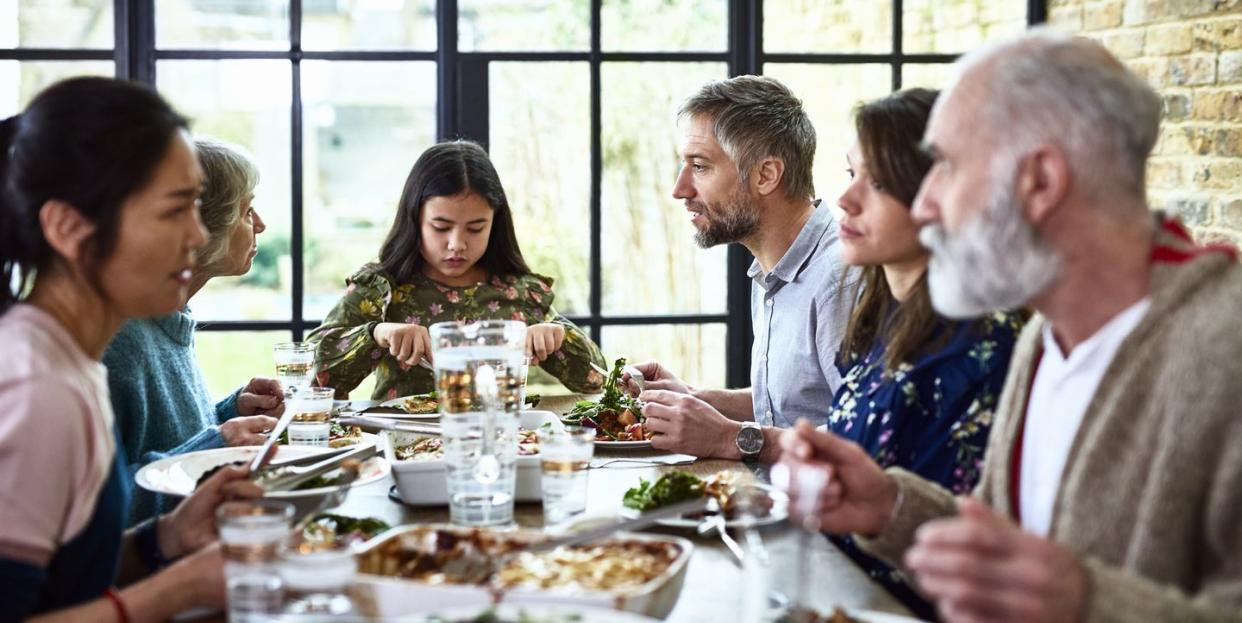 candid portrait of three generation family enjoying dinner together