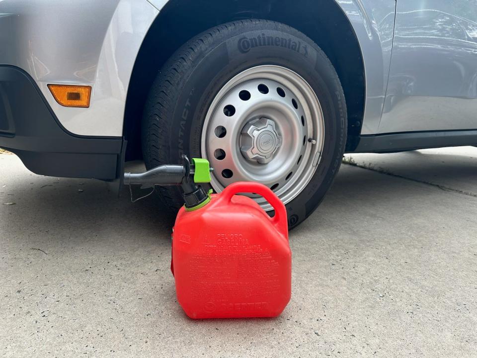 Jug of gasoline next to a tire