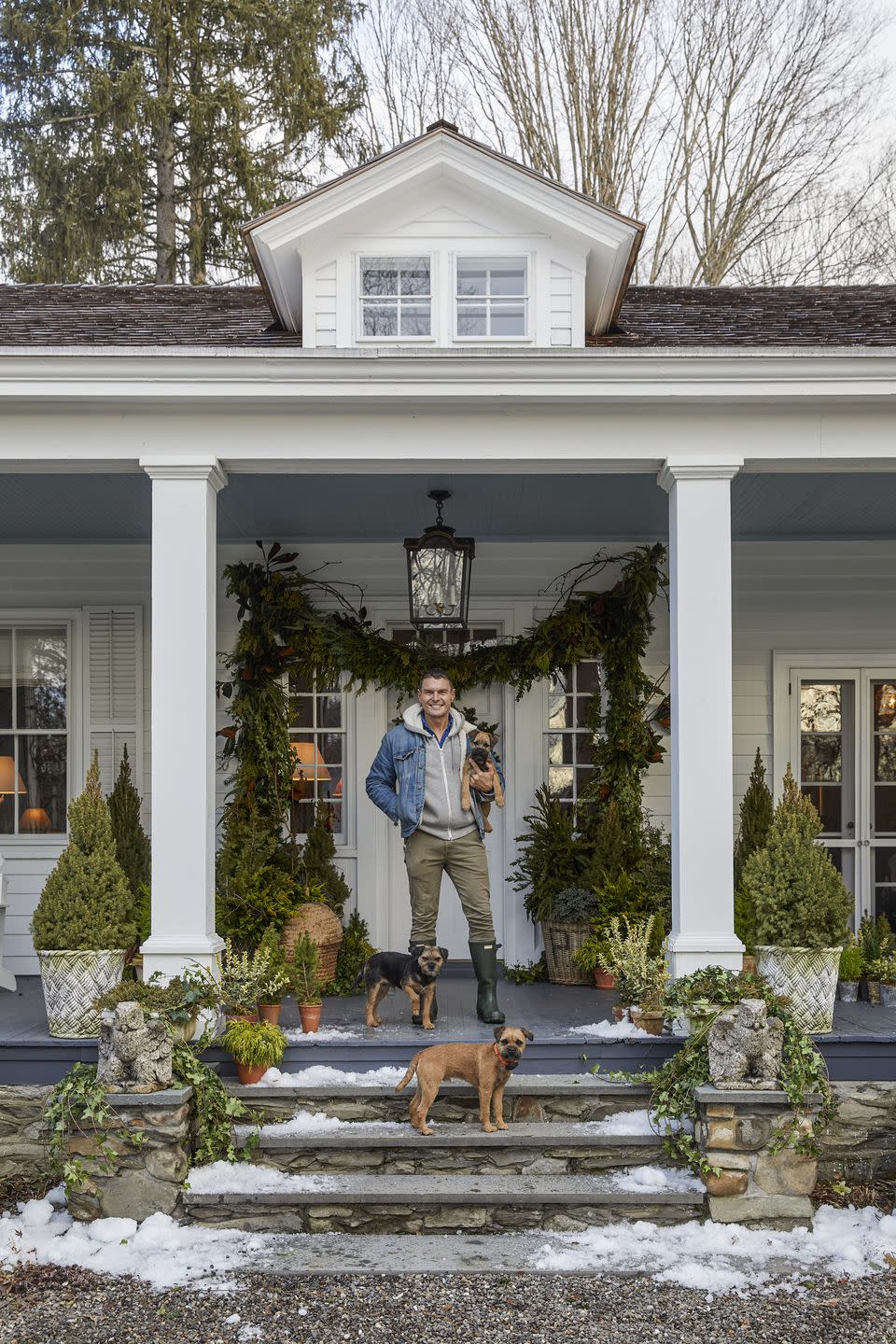 event planner lewis miller on the steps of his 1850 staatsburg cottage with his three dogs