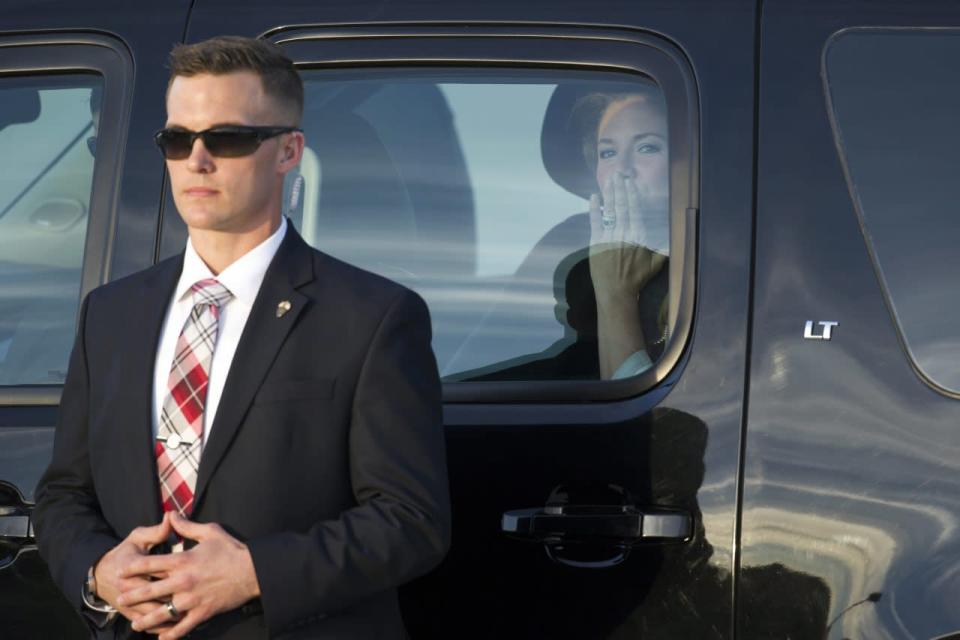 Sophie Grégoire-Trudeau, wife of Canadian Prime Minister Justin Trudeau, blows a kiss from inside a Secret Service vehicle, as a Secret Service agent stands guard, following their arrival at Andrews Air Force Base, Md., Wednesday, March 9, 2016. AP Photo/Cliff Owen