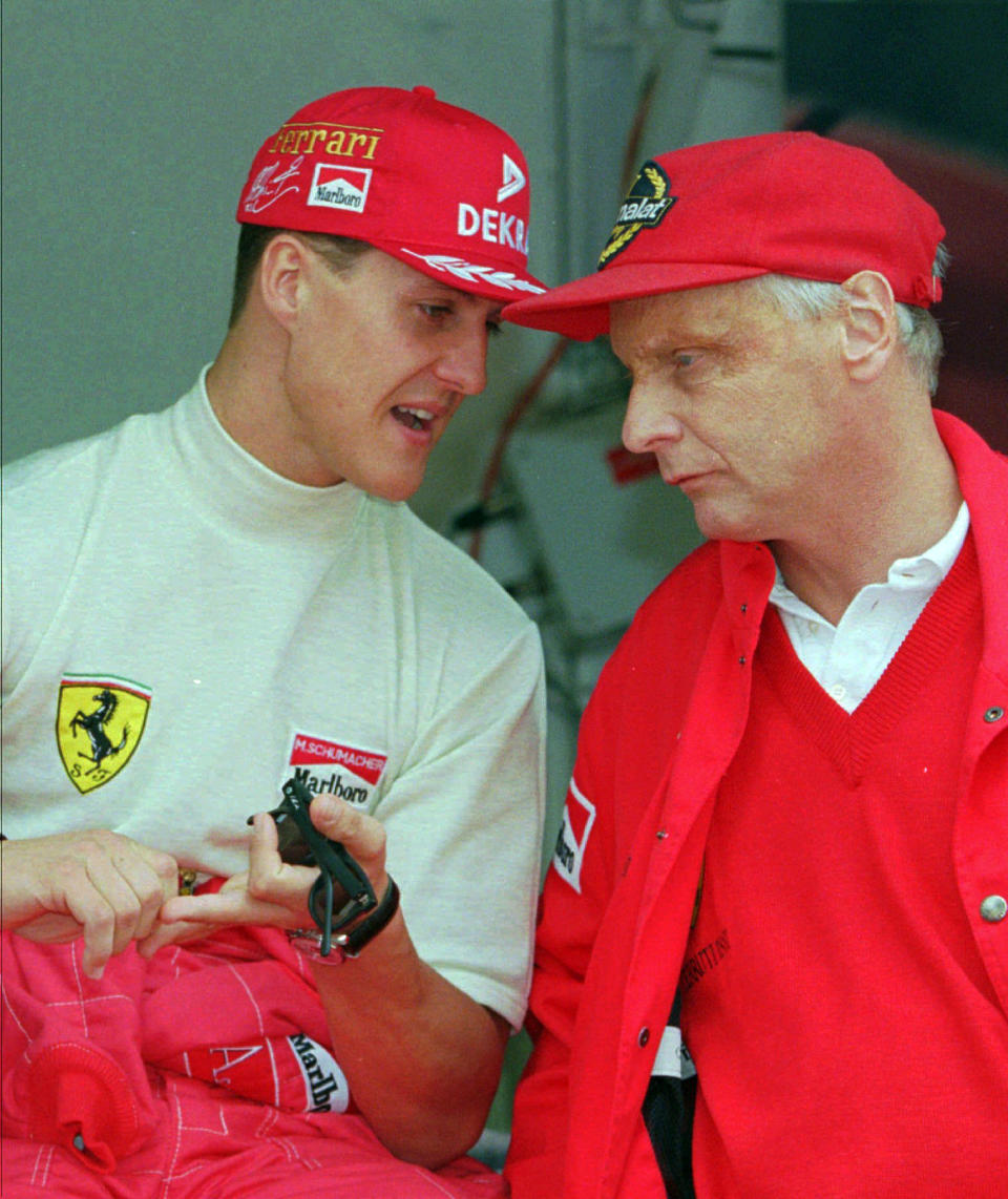 FILE - In this Thursday May 16, 1996 file photo defending champion Michael Schumacher of Germany, left, chats with Ferrari consultant Niki Lauda during the practice session for the Monaco F1 Grand Prix in the principality. Three-time Formula One world champion Niki Lauda, who won two of his titles after a horrific crash that left him with serious burns and went on to become a prominent figure in the aviation industry, has died. He was 70. (AP Photo/Lionel Cironneau, File)
