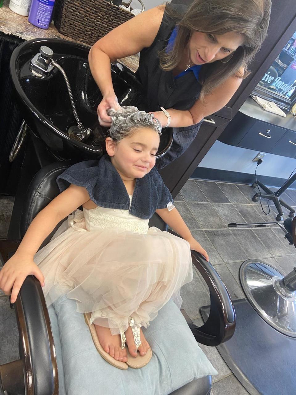 Ayla Robles, 5, gets her hair washed by Lisa Almeida of Positive Image Hair Design in Brockton. Ayla is donating her hair to Locks of Love, on Aug. 11, 2023.