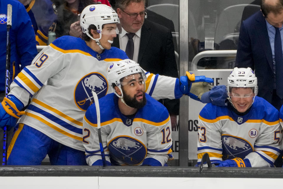 Buffalo Sabres center Peyton Krebs, left, places a hat thrown by a fan onto the shoulder of left wing Jeff Skinner, right, who scored a hat trick against the Seattle Kraken, as left wing Jordan Greenway (12) looks out to the ice during the third period of an NHL hockey game Monday, March 18, 2024, in Seattle. The Sabres won 6-2. (AP Photo/Lindsey Wasson)