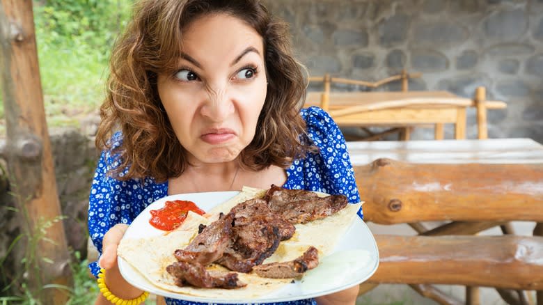 Woman looks disgusted by steak