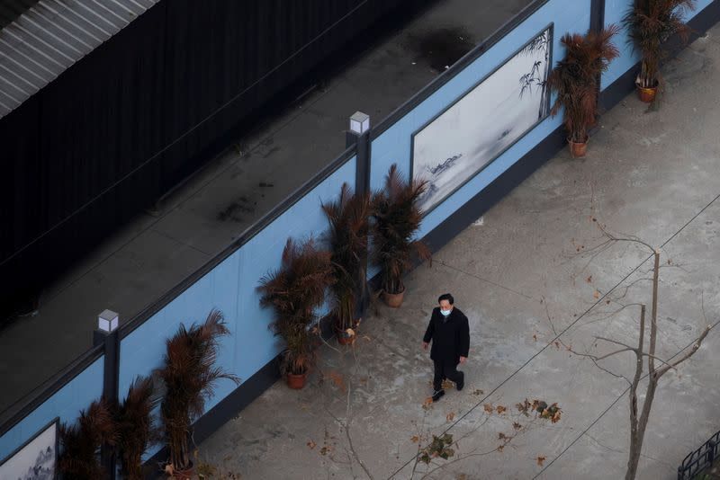 A man walks past the Huanan Wholesale Seafood Market following the arrival of a team of the World Health Organisation (WHO), tasked with investigating the origins of the coronavirus (COVID-19) pandemic, in Wuhan