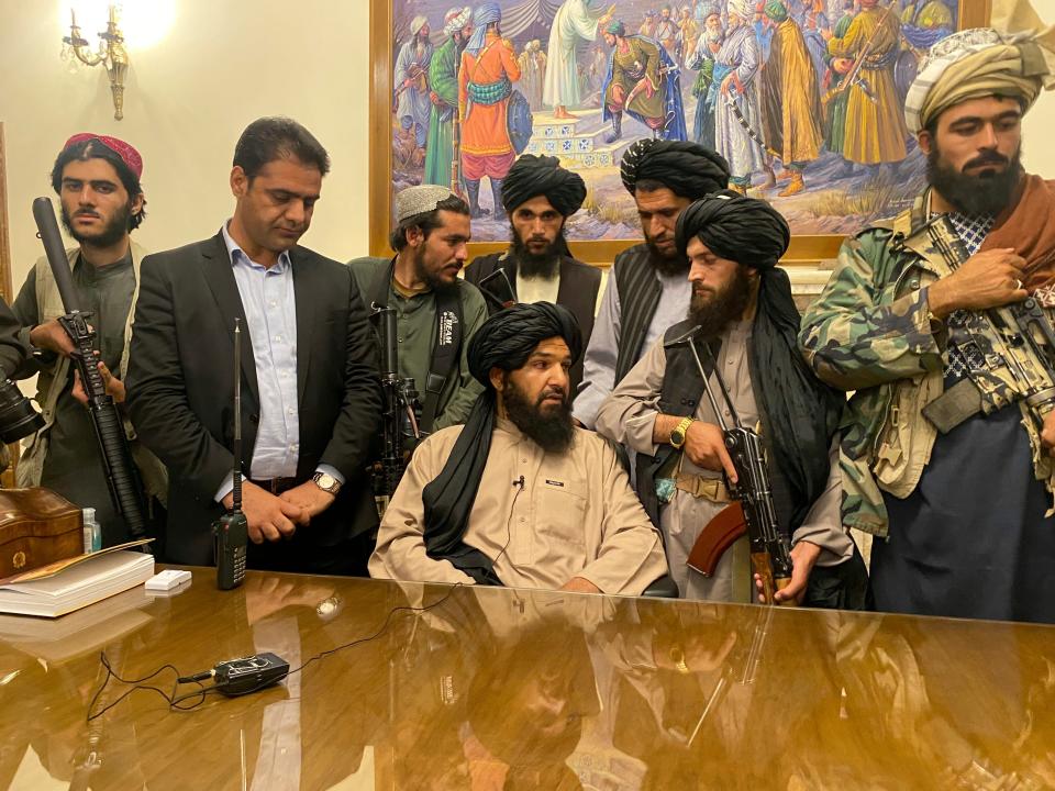 Taliban fighters sit in the Afghan presidential palace.