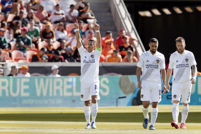 LA Galaxy forward Javier "Chicharito" Hernandez, left, reacts after a score as he and midfielders Sebastian Lletget (17) and Aleksandar Katai (7) walk back to midfield during the first half of an MLS soccer match against the Houston Dynamo, Saturday, Feb. 29, 2020, in Houston. (AP Photo/Michael Wyke)