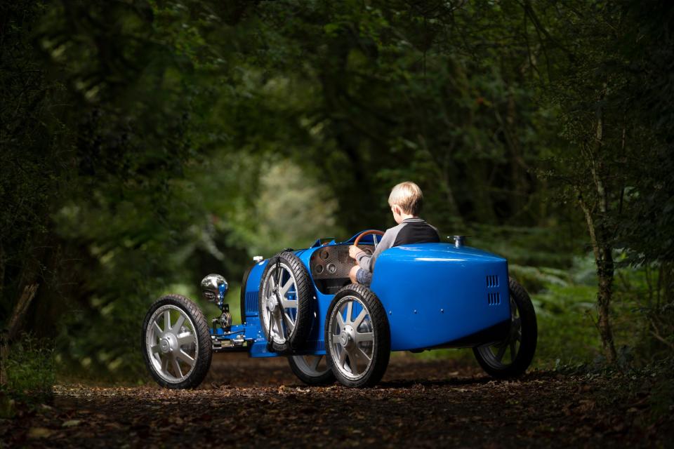 Bugatti-Boy steht im Wald: Bei beherztem Tritt auf das Strompedal schwingen sich Fratz und Fuhre schnell aus dem Stand auf Tempo 68 (42 mph) – sofern Erziehungsberechtigte den „Speed Key“ herausrücken. - Copyright: The Little Car Company