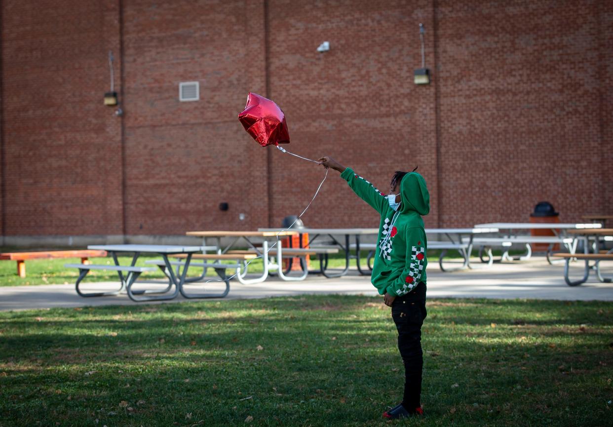 Terrell McCoy, 12, releases a balloon in honor of his older brother Pierre V. Scott Jr., 18, a Lanphier High School student who was stabbed and killed outside the school. Students at Lanphier, along with Southeast and Springfield, held a walkout in protest over security concerns after the death of Scott and also to honor him with a moment of silence, Friday, November 19, 2021 in Springfield, Ill. [Justin L. Fowler/The State Journal-Register]