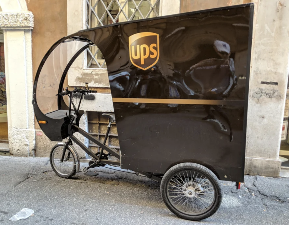 A rikshaw has been outfitted with a UPS branded back section that can hold several packages