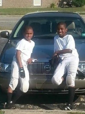 Lenier (left) and Mikhail Pocknett pose for a picture before a youth football game in Goldbsoro.