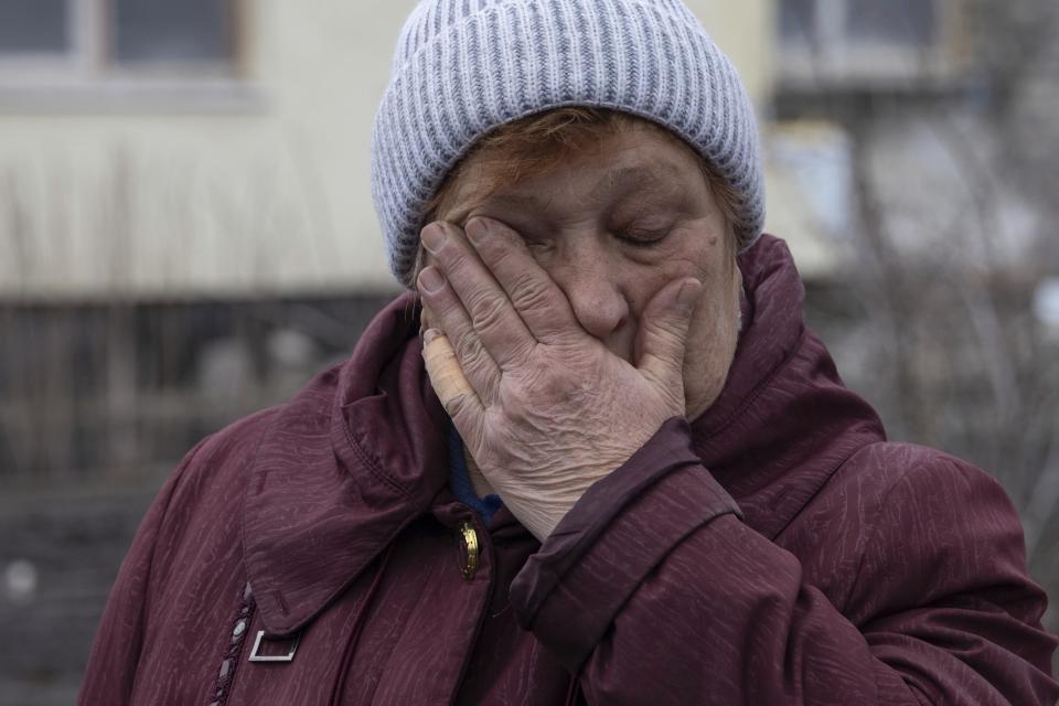 Liudmyla Momot weeps as she searches for any still-usable items Friday, Dec. 10, 2021, in the debris of her house in the village of Nevelske in eastern Ukraine, that was struck by a mortar shell fired by Russia-backed separatists. Her village, northwest of the rebel-held city of Donetsk, is only about 3 kilometers (2 miles) from the line of contact between the separatists and the Ukrainian military and has been emptied of all but five people. Small arms fire frequently is heard in the daytime, giving way to the booms of light artillery and mortars after dusk. (AP Photo/Andriy Dubchak)