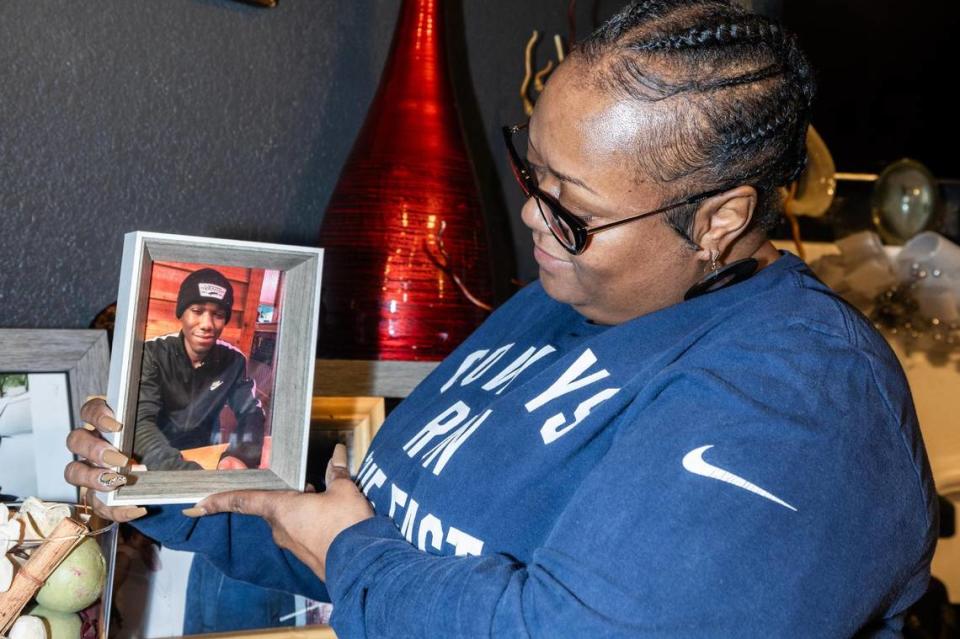 LaKeisha Mackey, the co-founder of Mothers of Murdered Angels (MOMA), holds her favorite picture of her son Derrick Johnson at her home in Fort Worth on Friday, Dec. 1, 2023. Mackey’s son Derrick, 19, was killed in a shooting in 2020. Along with her son, she also lost her uncle in 1980, her father in 1989 and her sister in 2017, all to gun violence.