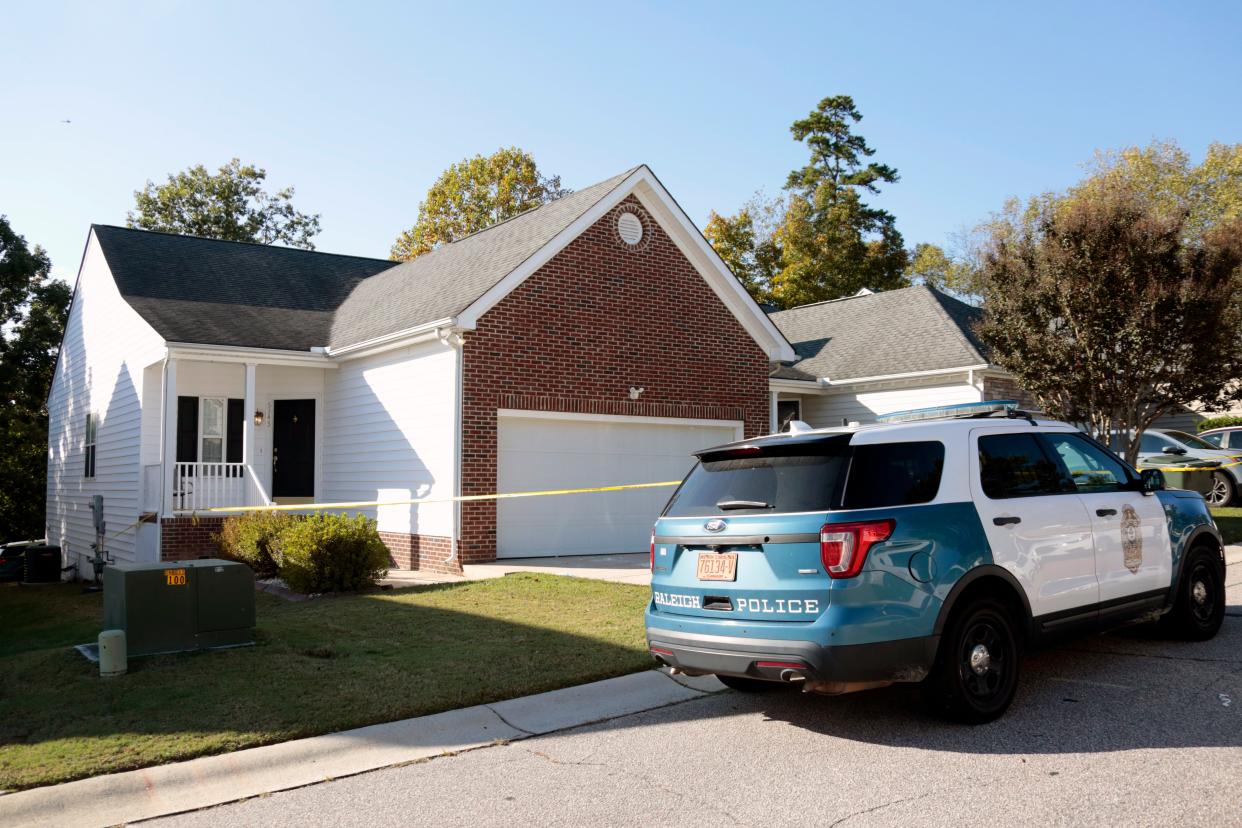 A police officer remains in front of the house where the suspected shooter lived on Sahalee Way following a shooting in Raleigh, N.C., Friday, Oct. 14, 2022. Several people were shot and killed by a gunman in the neighborhood Thursday night, Oct. 13. 