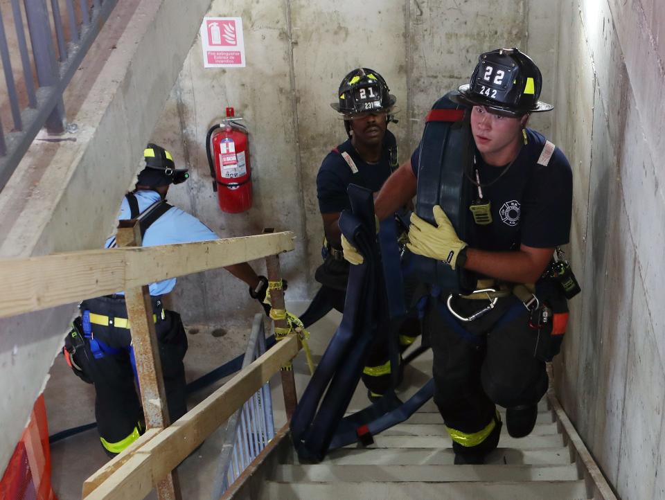 New Rochelle firefighters advance a hose line up a staircase on the upper floors of a high-rise under construction at 500 Main Street in downtown New Rochelle Aug. 1, 2023. 
