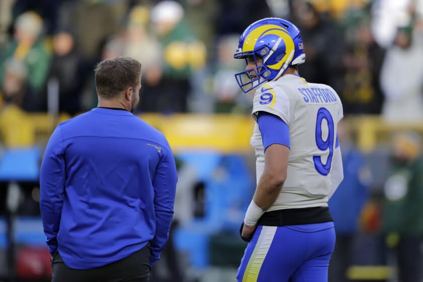 Los Angeles Rams' Matthew Stafford talks with head coach Sean McVay before an NFL football game against the Green Bay Packers Sunday, Nov. 28, 2021, in Green Bay, Wis. (AP Photo/Aaron Gash)